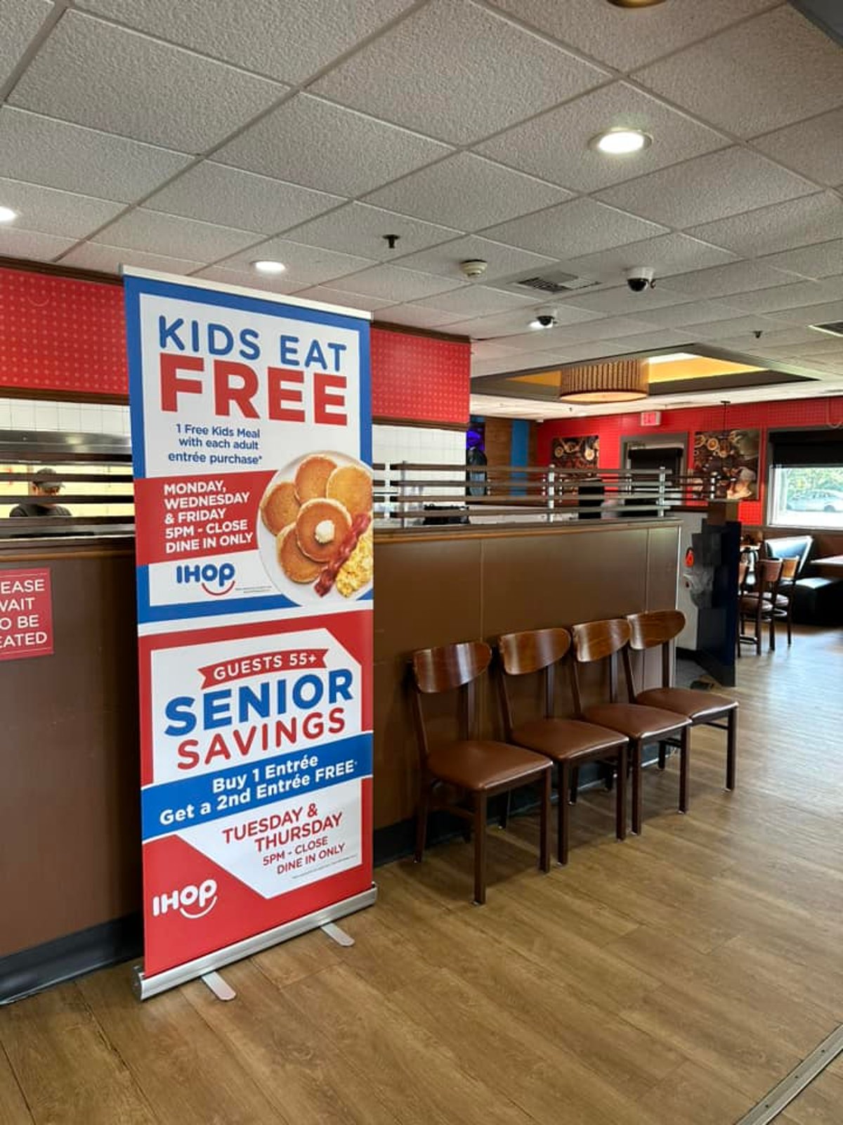 Retractable banner promoting kids eat free inside a restaurant