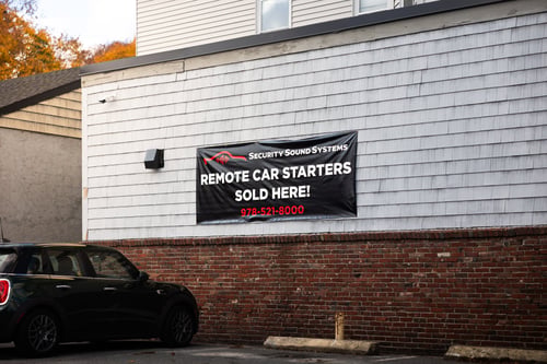 Security Sound Systems banner reading Remote Car Starters Sold Here on the side of their building in Haverhill, MA