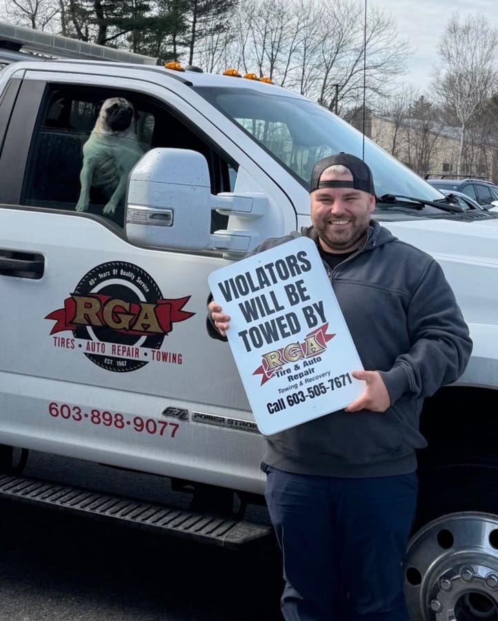 Customer holding a printed towing sign beside his truck