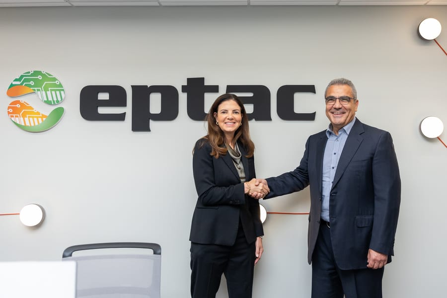 Executives shaking hands in front of the company logo