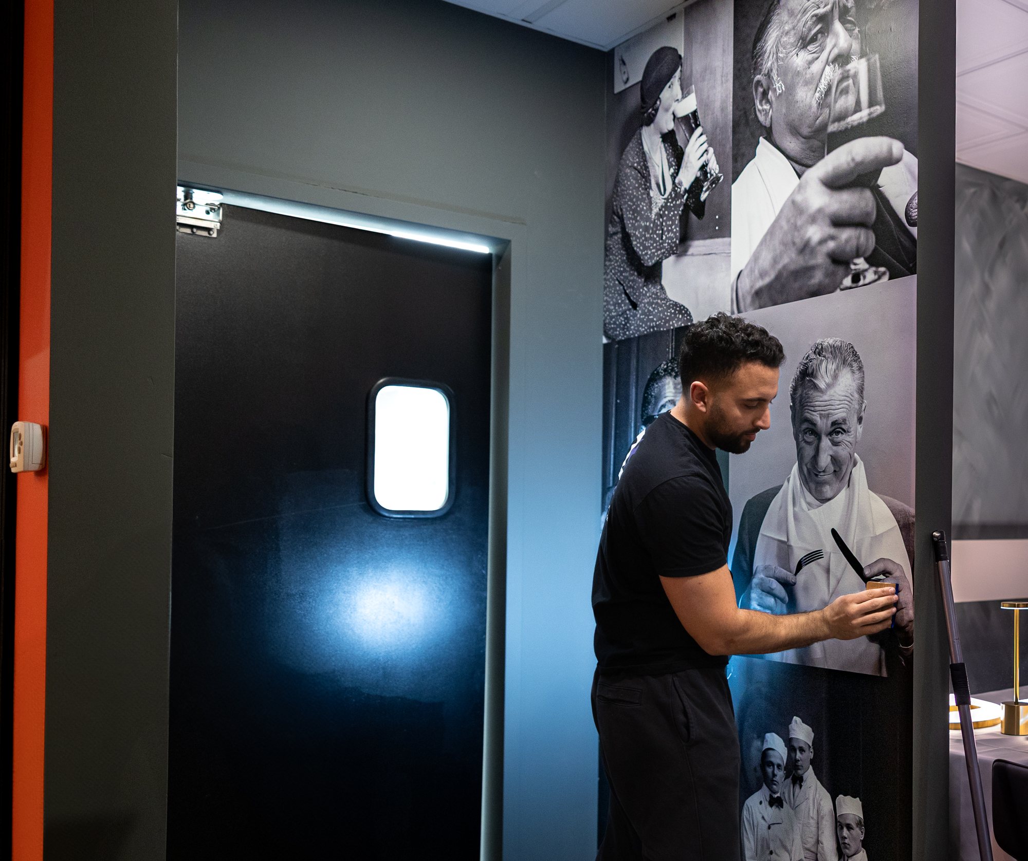 Joe trimming a black and white vintage photo wall wrap by the kitchen door at DREO